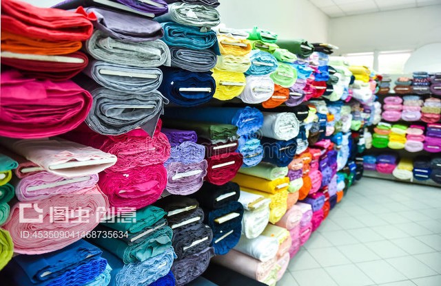 工廠里的布料和紡織品卷。Rolls of fabric and textiles in a factpory shop.