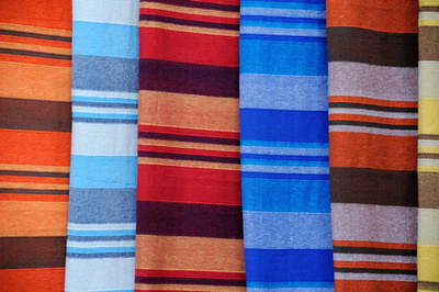 有圖案的棉紡織品。 有粉紅色和白色條紋的棉花。 粉紅色紡織品背景。 床上用白色和粉紅色的棉布顏色。 為家庭生產紡織品。 有圖案的